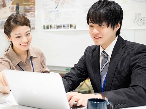 パソコンを教えるインストラクターと教わる新入社員